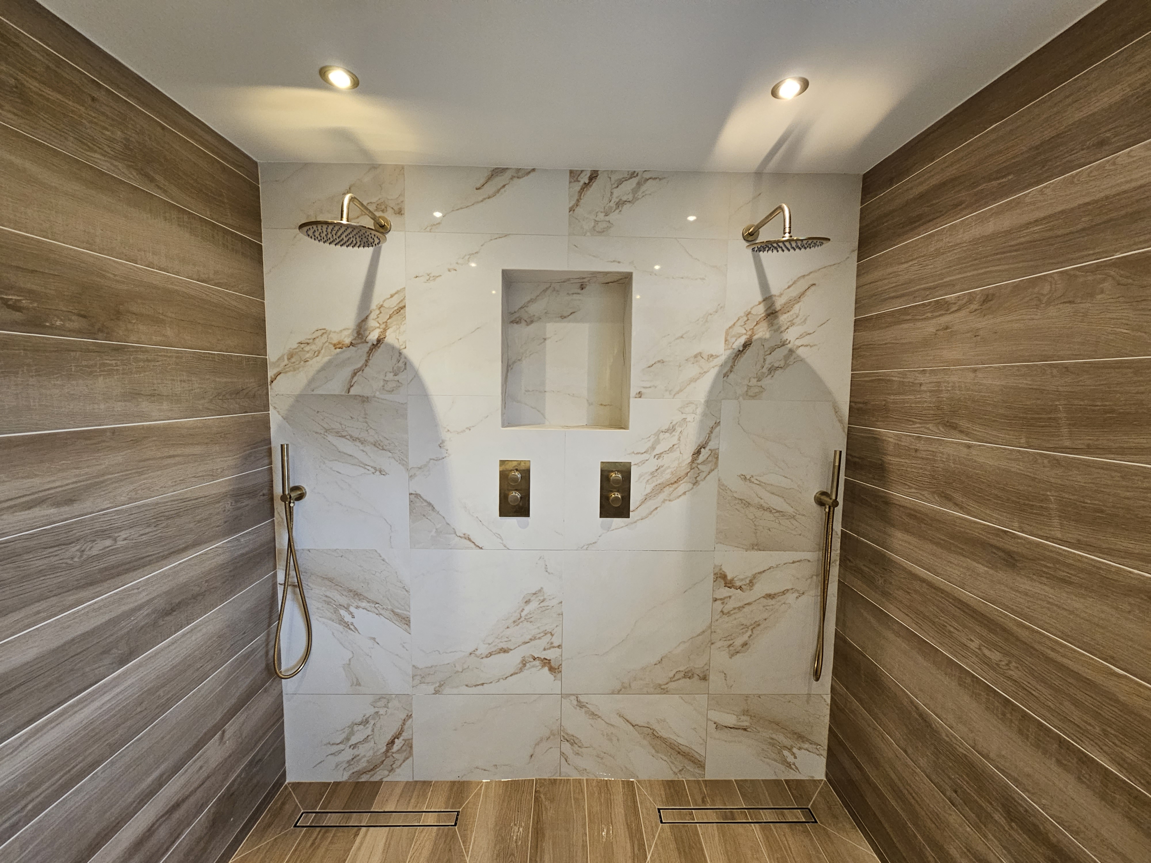 Double walk-in shower with marble and timber effect tiles