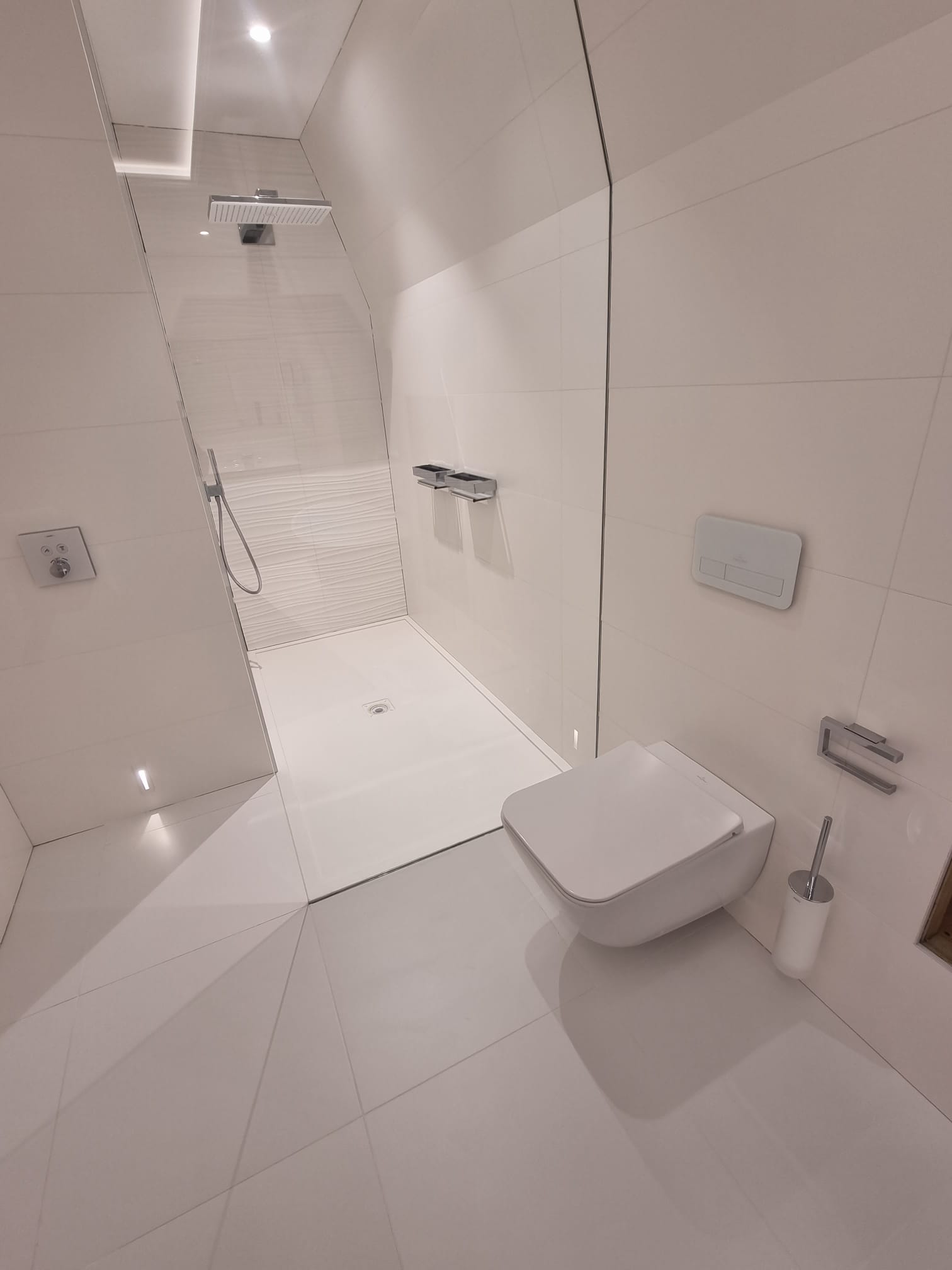 Seamless white walk-in shower with frameless glass screen