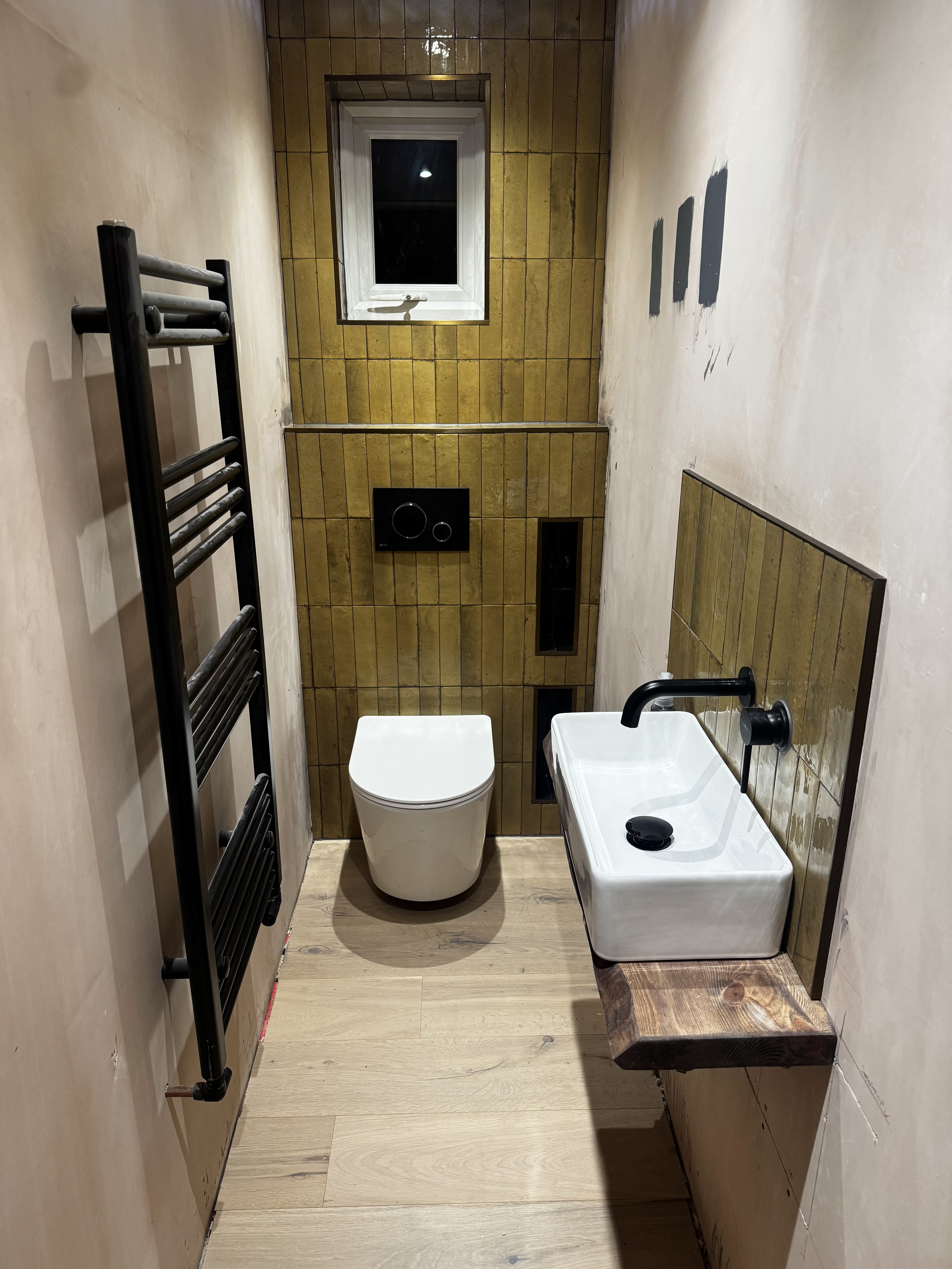 Bathroom installation with heated towel rail and black fittings